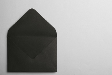 Black paper envelope on light background, top view. Space for text
