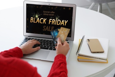 Woman with credit cards shopping online using laptop at home, closeup. Black Friday Sale
