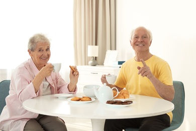 Photo of Elderly people having breakfast at nursing home. Assisting senior people