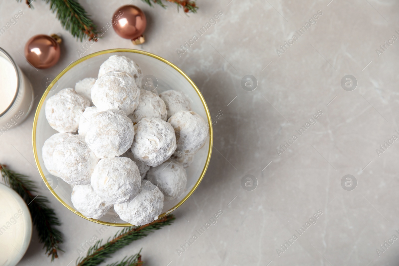 Photo of Flat lay composition with Christmas snowball cookies in bowl on light table, space for text