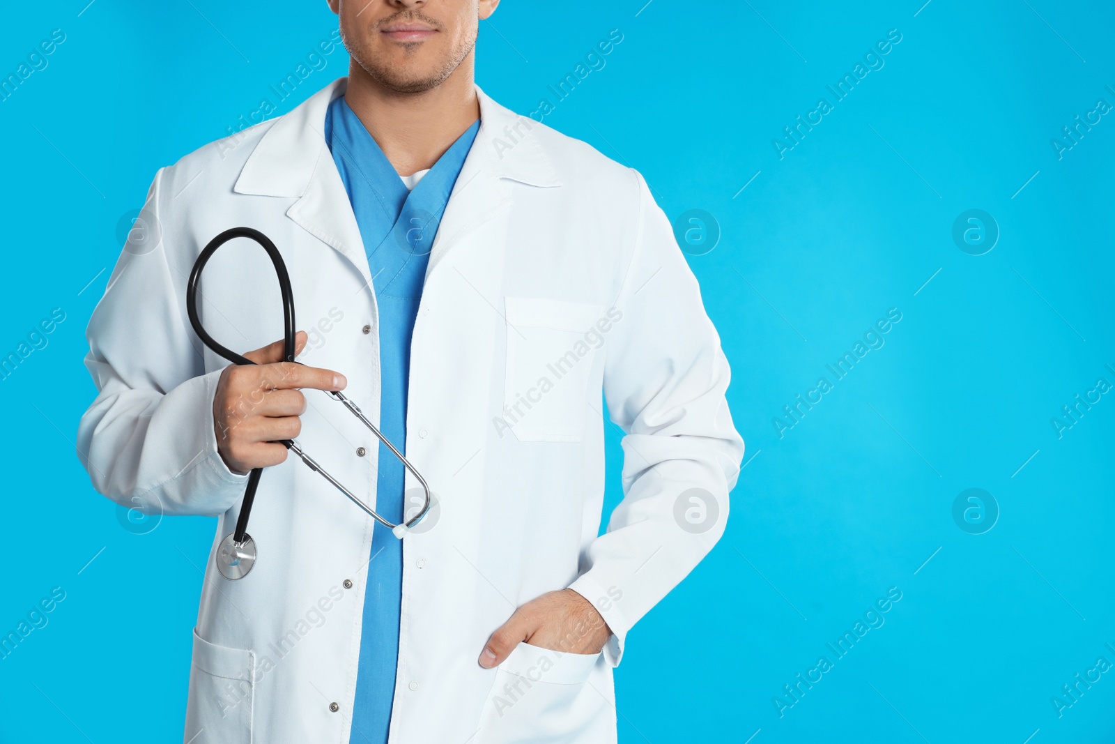 Photo of Doctor with stethoscope on blue background, closeup. Space for text