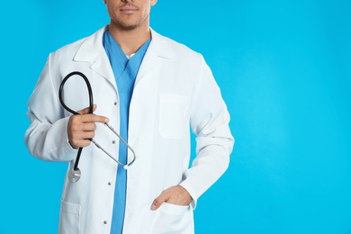 Photo of Doctor with stethoscope on blue background, closeup. Space for text