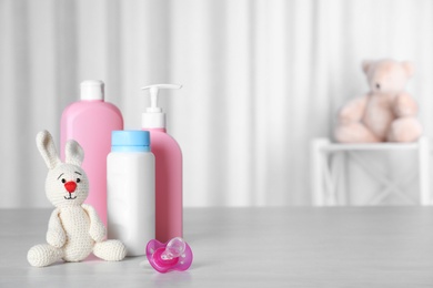 Photo of Baby accessories and toy on table against light background. Space for text
