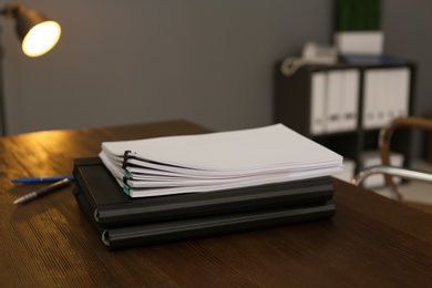 Stack of documents on wooden table in office