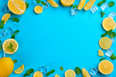 Photo of Frame made of lemon slices, mint and ice on blue background, top view with space for text. Lemonade layout