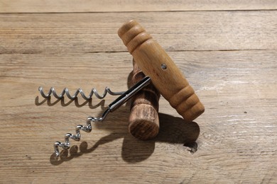 Photo of Two different corkscrews on wooden table. Kitchen utensil