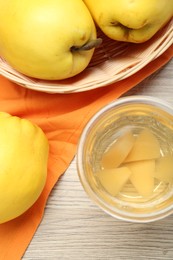 Photo of Delicious quince drink in glass and fresh fruits on wooden table, top view