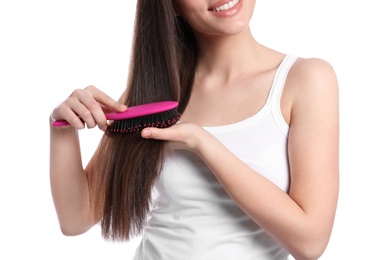 Woman with hair brush on white background, closeup