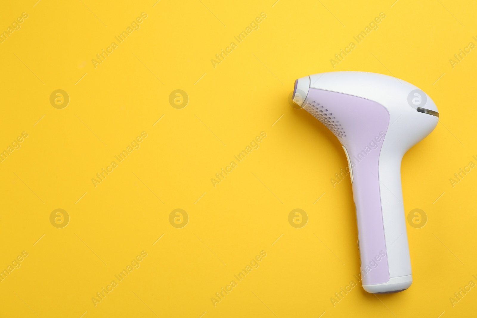 Image of Modern photoepilator on yellow background, top view. Space for text