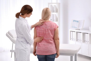 Chiropractor examining patient with back pain in clinic