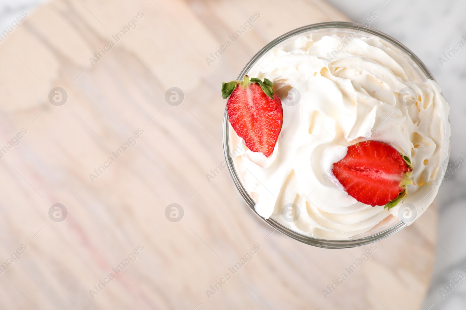 Photo of Tasty milk shake with topping on wooden board, top view. Space for text