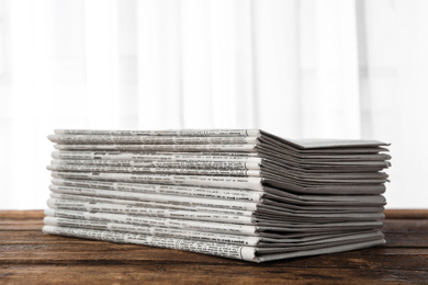 Stack of newspapers on wooden table. Journalist's work