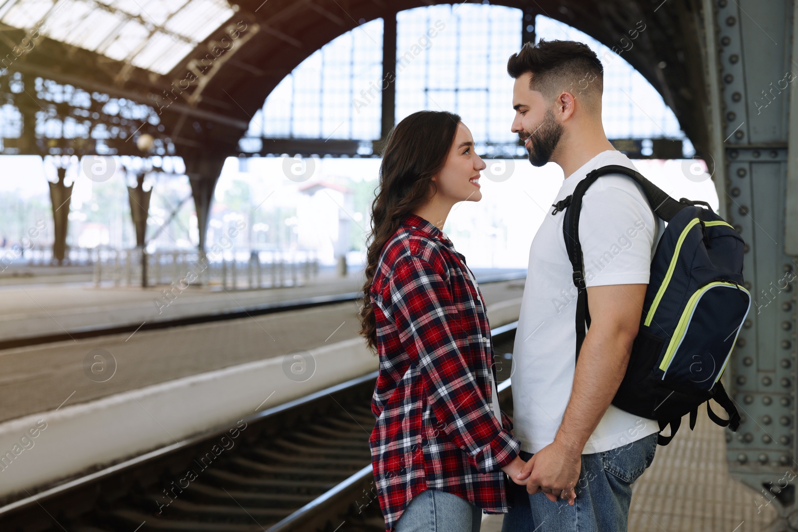 Photo of Long-distance relationship. Beautiful couple on platform of railway station, space for text