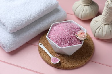 Photo of Composition with sea salt and herbal bags on pink wooden table