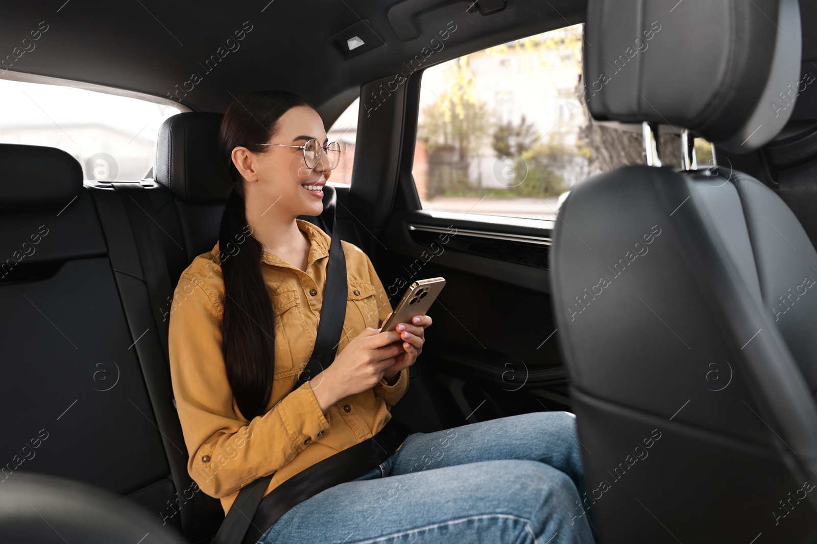 Photo of Woman with seatbelt using phone inside car