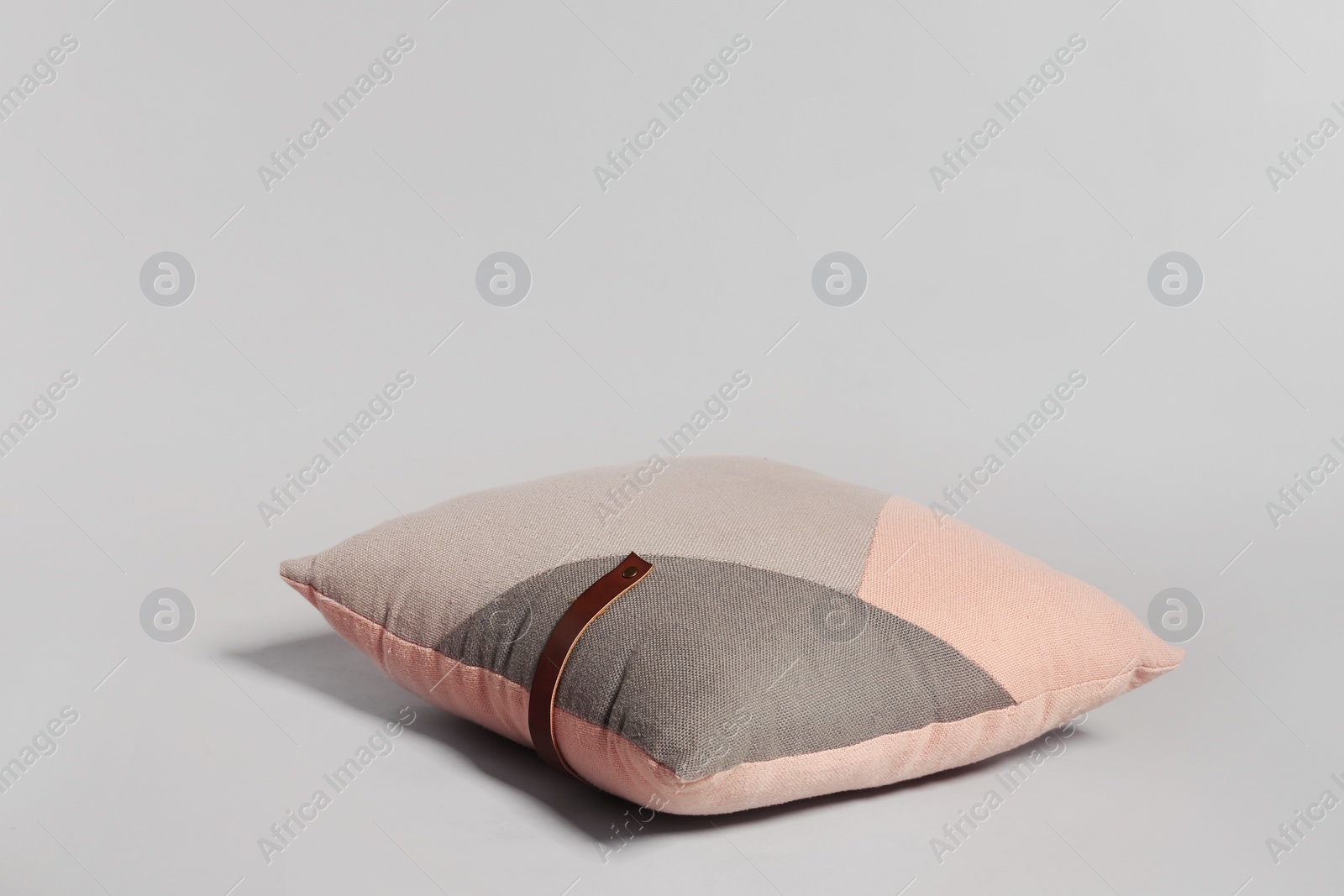 Photo of Single stylish decorative pillow on light background