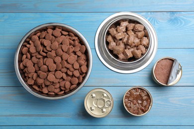 Photo of Wet and dry pet food on light blue wooden table, flat lay