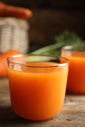 Photo of Freshly made carrot juice on wooden table