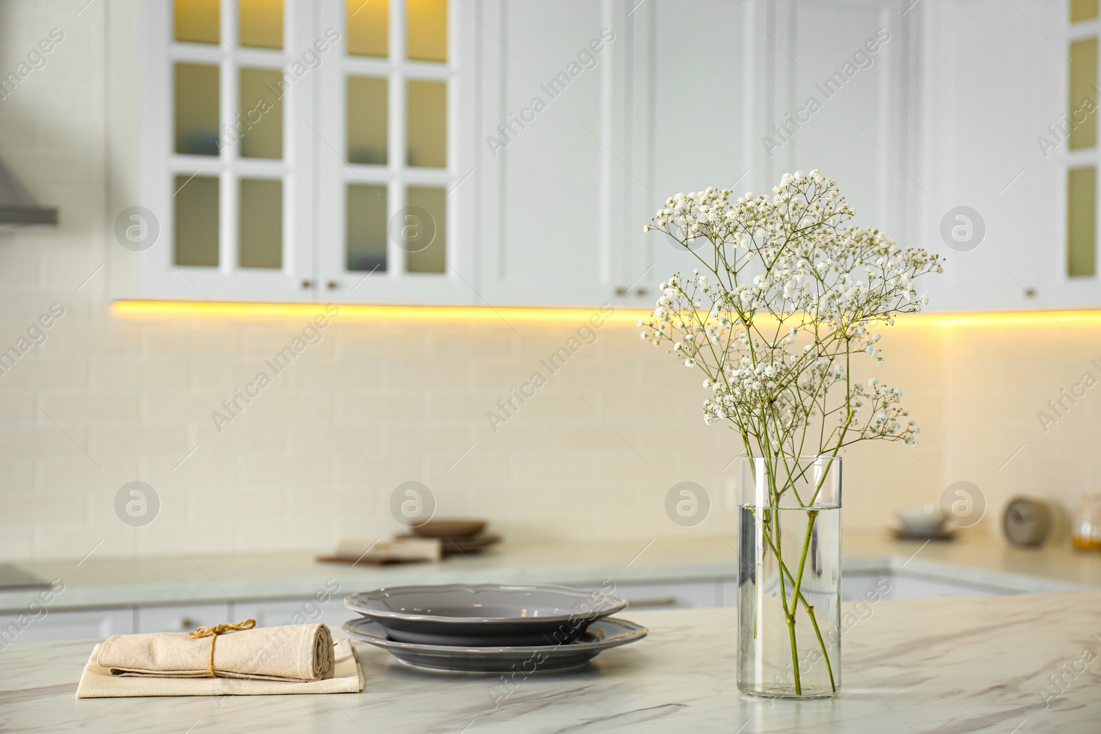 Photo of Beautiful plates and bouquet on table in kitchen