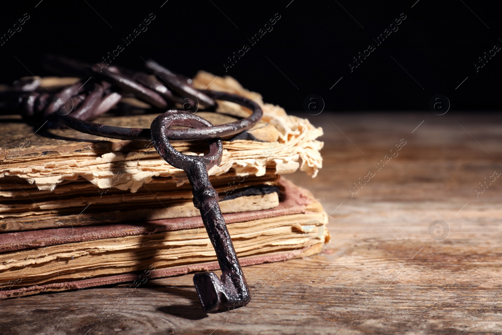 Photo of Bunch of old vintage keys with books on wooden table, space for text