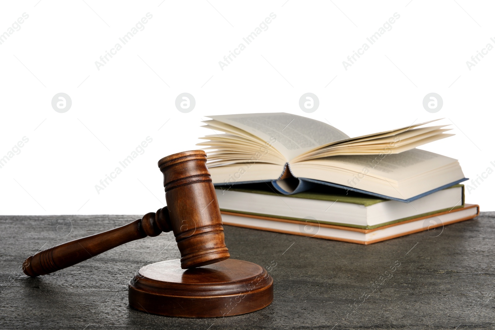 Photo of Law concept. Judge's mallet and books on dark grey table against white background