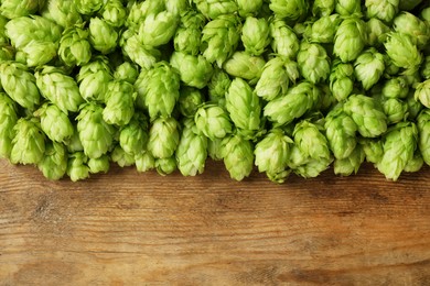 Fresh green hops on wooden table, top view. Space for text