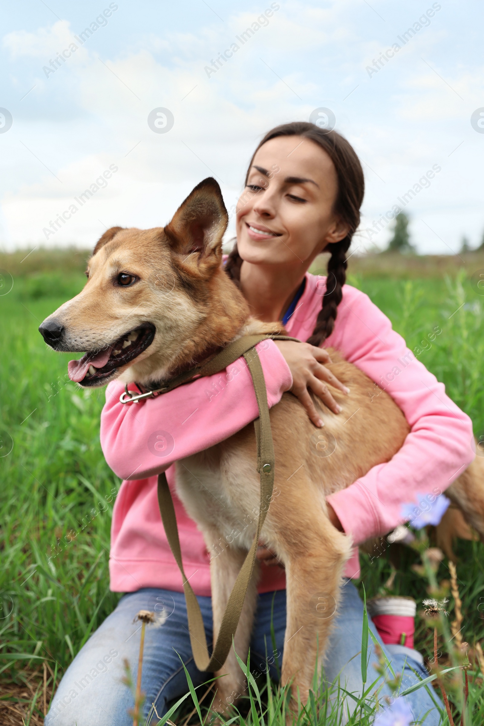 Photo of Female volunteer with homeless dog at animal shelter outdoors