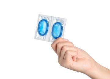 Woman holding condoms on white background, closeup