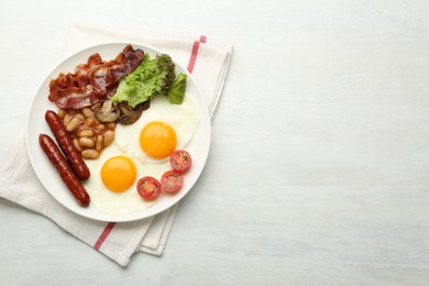 Photo of Delicious breakfast with sunny side up eggs on white table, top view. Space for text