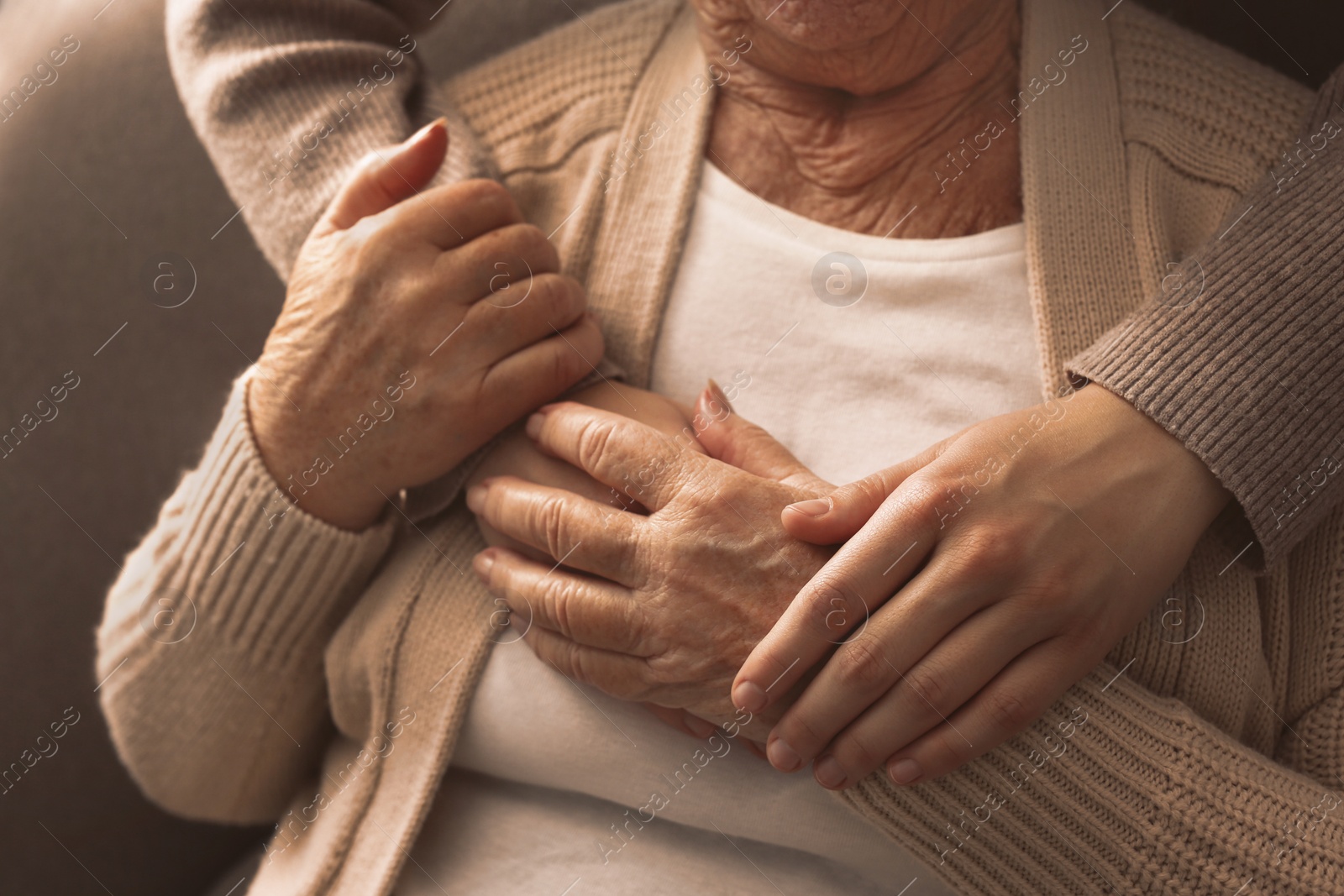 Photo of Young and elderly women hugging, closeup view