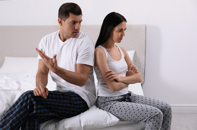 Photo of Unhappy couple with relationship problems after quarrel in bedroom