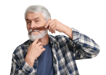 Photo of Senior man combing beard with comb on white background