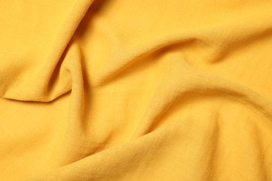 Photo of Texture of soft yellow crumpled fabric as background, top view