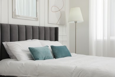 Photo of Large comfortable bed with cushions in bedroom. Interior design