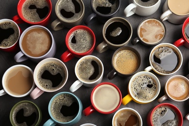Photo of Many cups with tasty aromatic coffee on table, flat lay