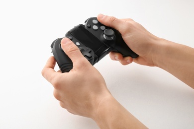 Photo of Young man holding video game controller on white background, closeup