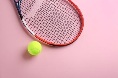Photo of Tennis racket and ball on pink background, flat lay. Space for text