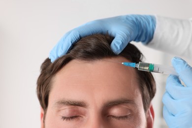 Photo of Trichologist giving injection to patient in clinic, closeup