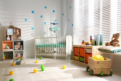 Photo of Cozy baby room interior with comfortable crib