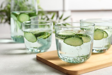 Photo of Glasses of fresh cucumber water on table. Space for text