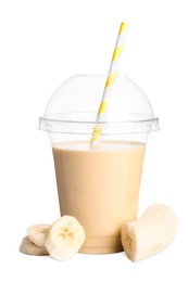 Photo of Plastic cup of tasty banana smoothie and fresh fruit on white background
