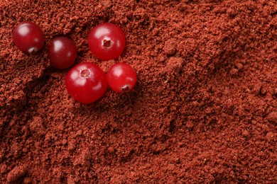 Photo of Fresh berries on cranberry powder, top view