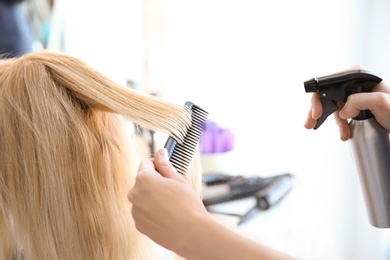 Photo of Professional hairdresser working with client in salon