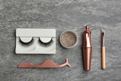 Photo of Flat lay composition with magnetic eyelashes and accessories on grey table