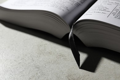 Photo of Open Bible on light gray table, closeup with space for text. Christian religious book