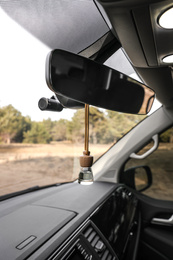 Photo of Air freshener hanging on rear view mirror in car