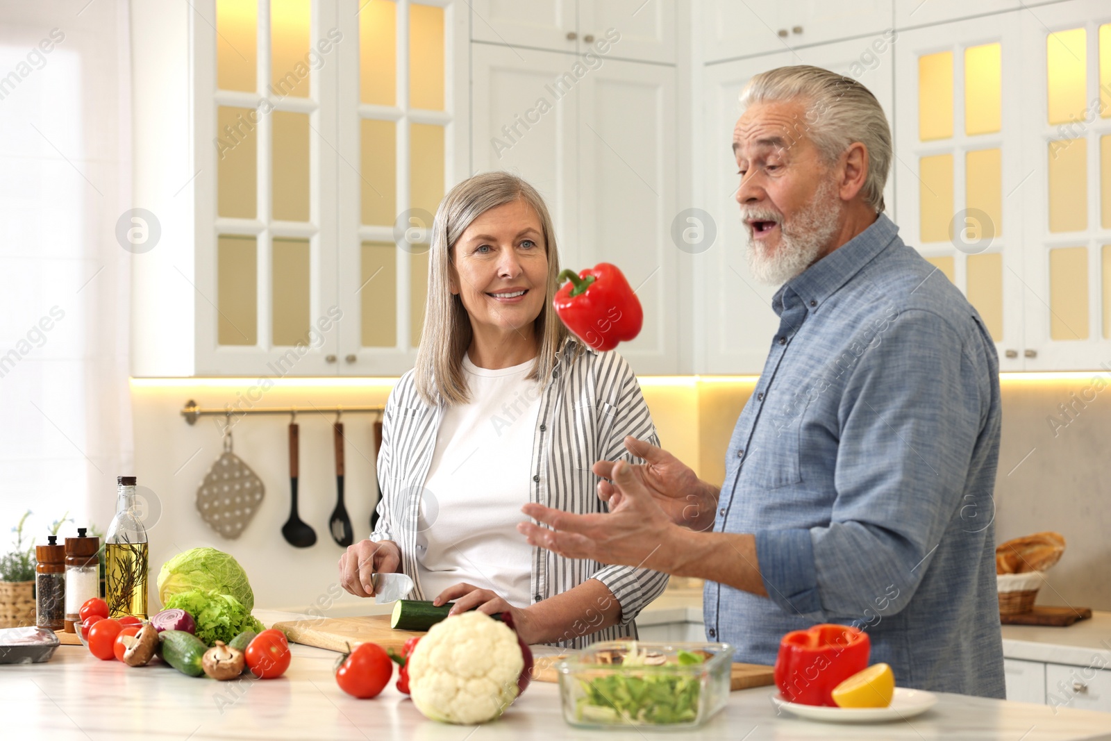 Photo of Happy senior couple cooking together in kitchen