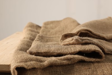 Photo of Natural burlap fabric on wooden table, closeup