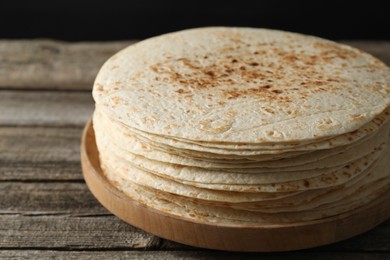 Photo of Stack of tasty homemade tortillas on wooden table