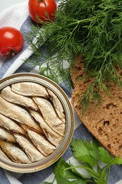 Photo of Canned sprats, herbs, tomatoes and bread on table, flat lay